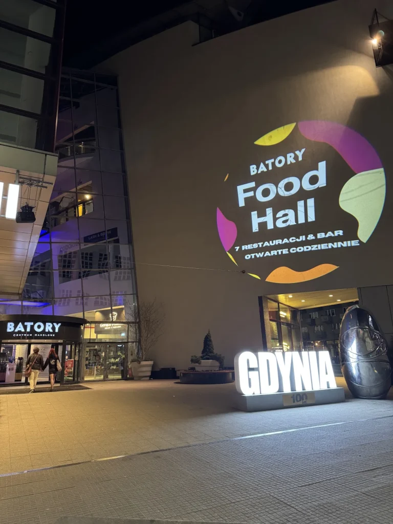Okrągła grafika Batory Food Hall wyświetlona na ścianie galerii