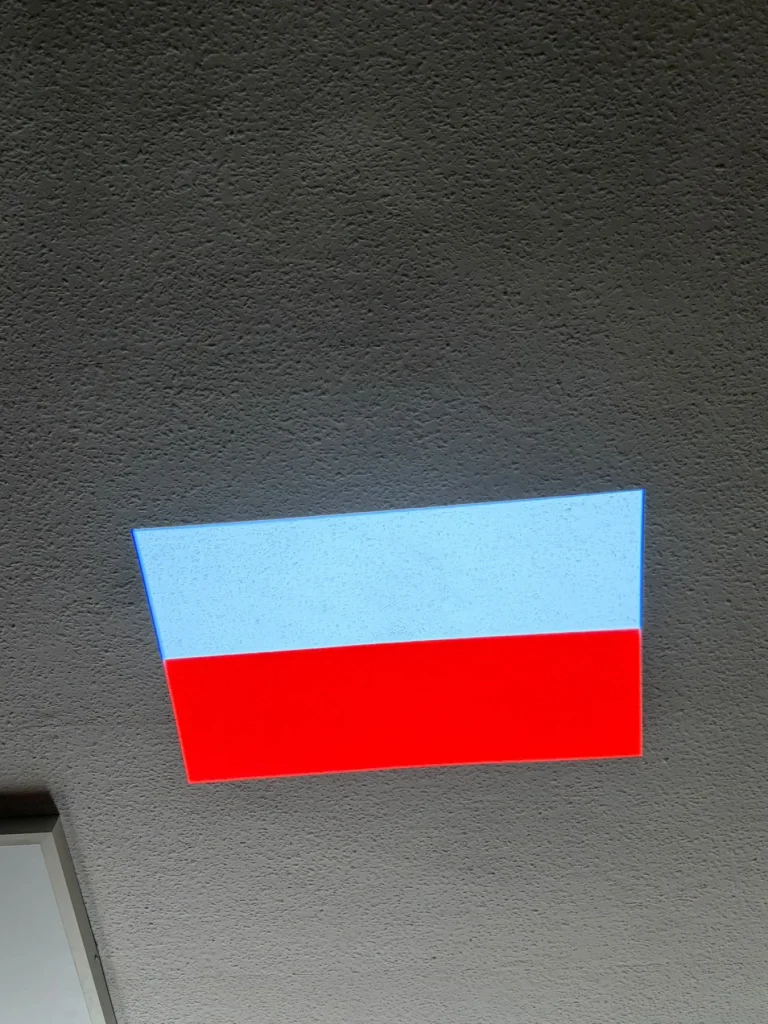 Flaga Polski wyświetlona projektorem GOBO na elewacji budynku w Bolesławcu