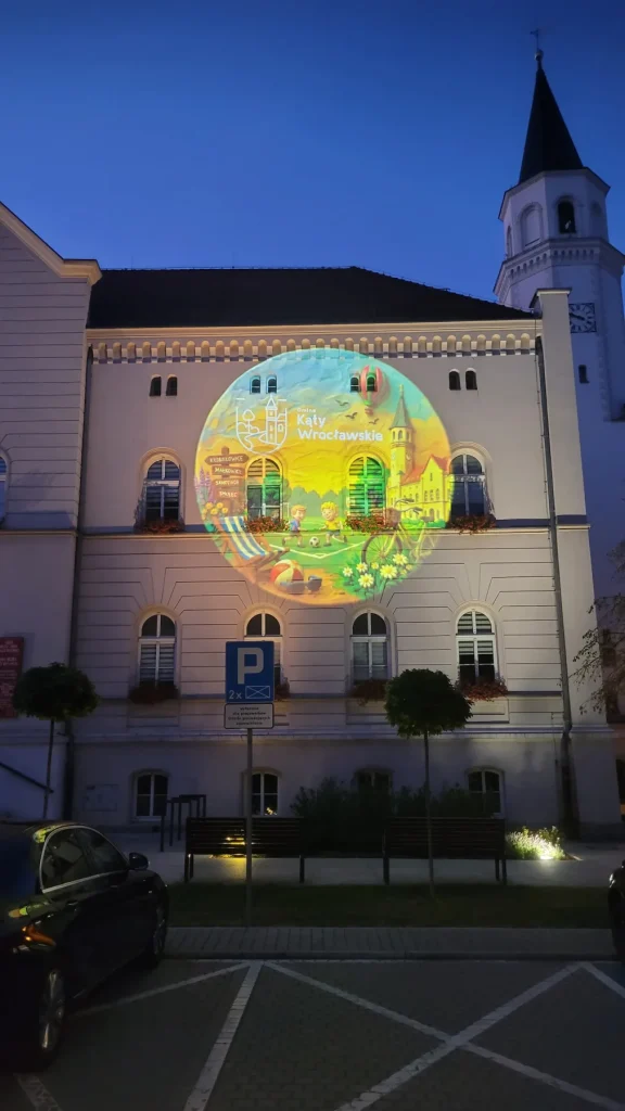 Grafika promocyjna gminy Kąty Wrocławskie wyświetlona na budynku przy Rynku