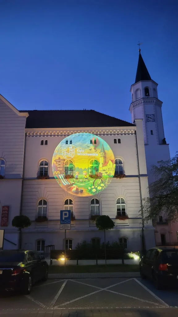 Kolorowa grafika GOBO wyświetlona na elewacji ratusza w Kątach Wrocławskich