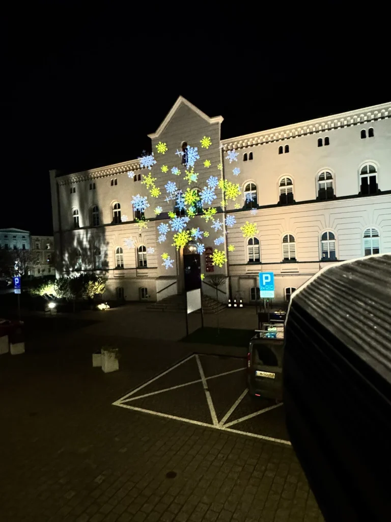 Ruchome śnieżynki na elewacji ratusza w Kątach Wrocławskich po zmroku