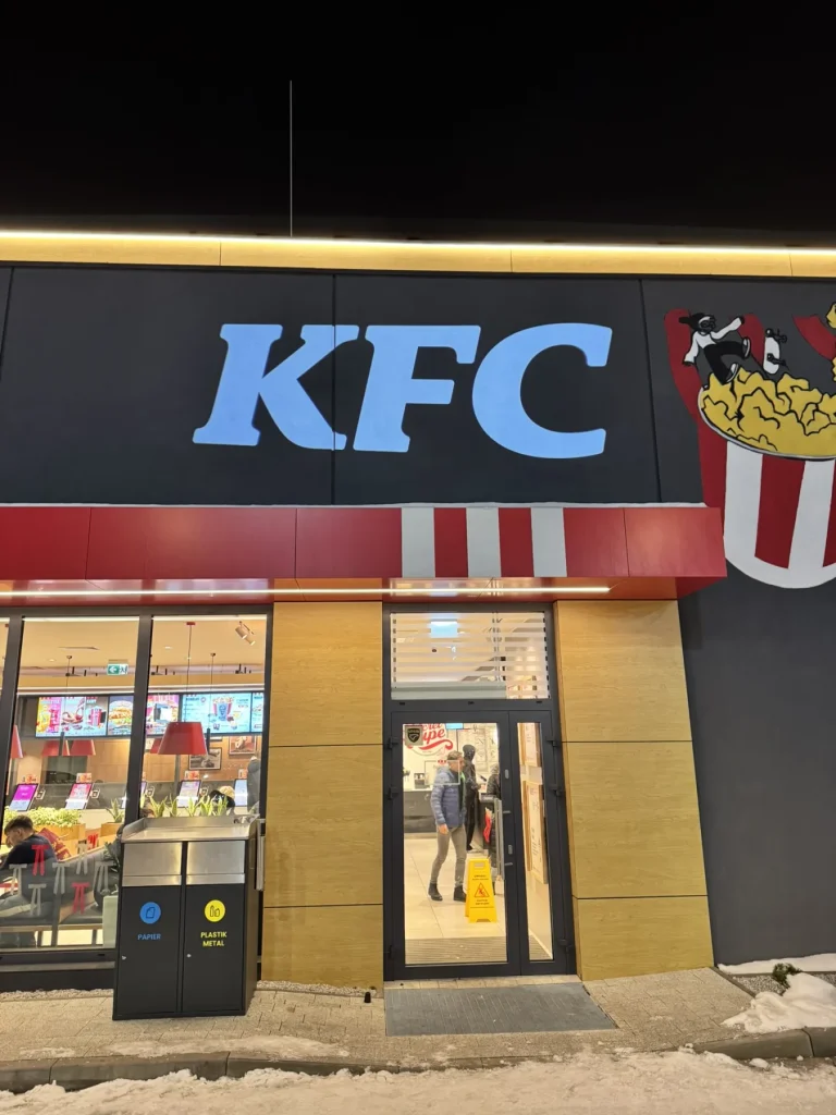 Projekcja logo KFC na ścianie restauracji obok wejścia