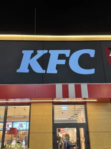 Logo KFC wyświetlone projektorem GOBO na elewacji restauracji po zmroku