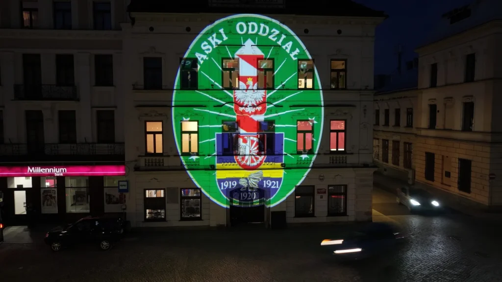Godło Śląskiego Oddziału Straży Granicznej wyświetlone projektorem GOBO na kamienicy w Cieszynie